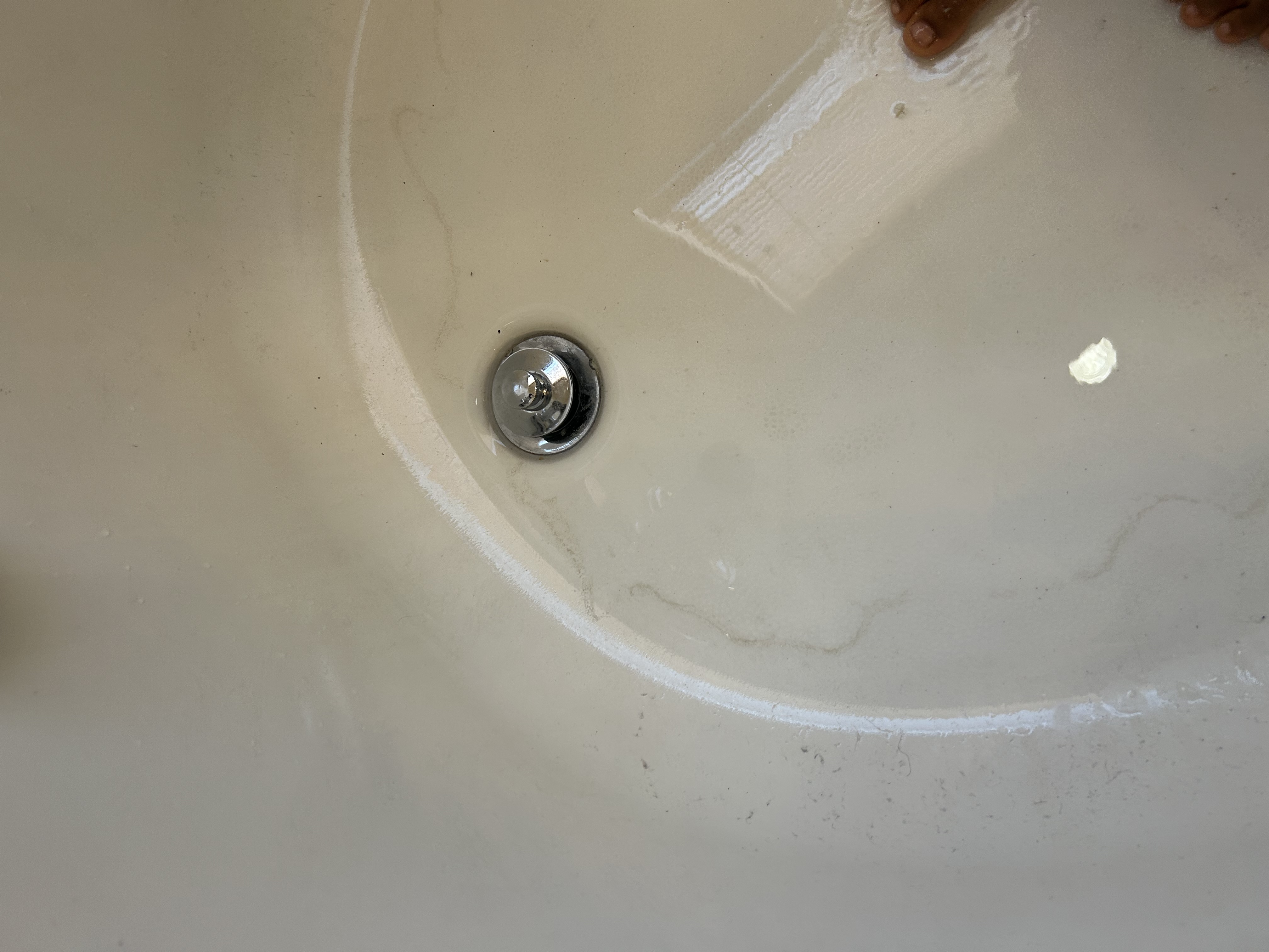 Standalone soaking tub in Peoria AZ master bath — hard water mineral stains visible, drain cleared by Desert Rain Plumbing