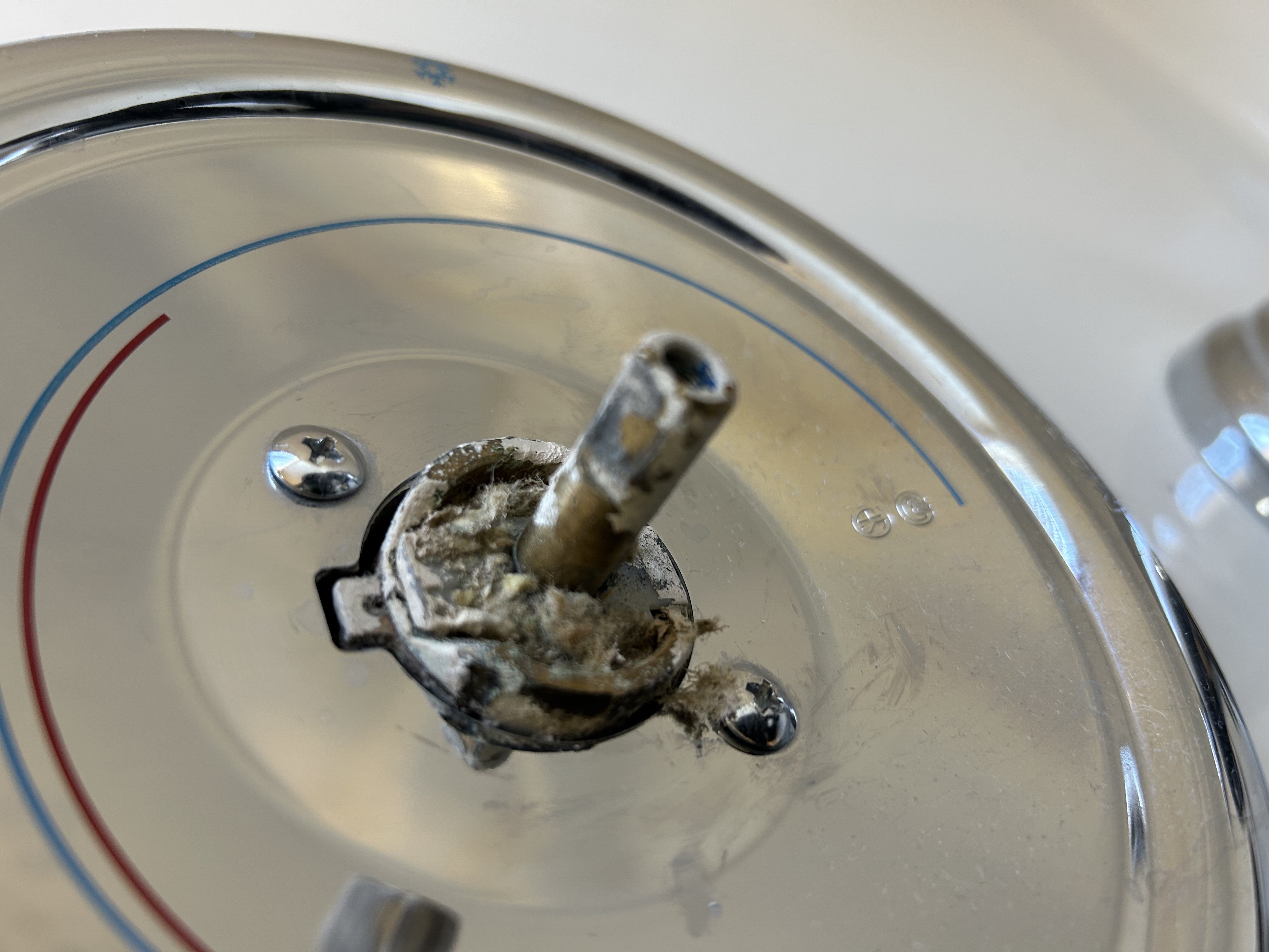 Close-up of corroded Moen cartridge stem seized in valve — mineral buildup from Phoenix hard water